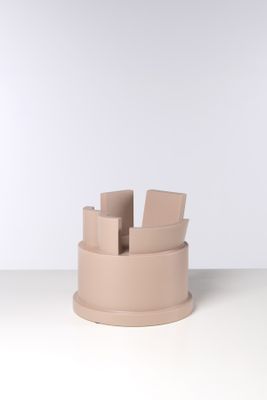 un gros plan d'un vase rose posé sur une table, sur fond blanc