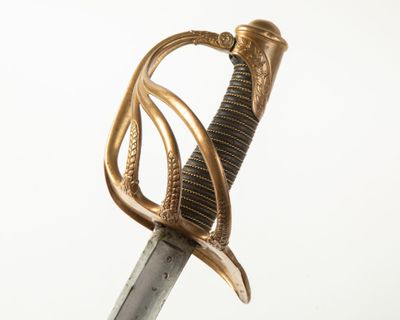 a close up of a sword with a gold handle on a white background