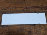 an image of a white license plate sitting on top of a wooden table