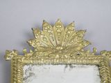 a mirror with a gold frame on the wall