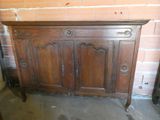 an old wooden cabinet sitting in a room next to a brick wall