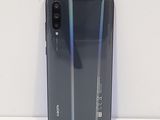 a close up of the back of a black phone on a white surface