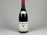 une bouteille de vin rouge posée sur une table blanche