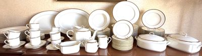 a lot of white dishes and cups on a table