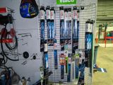 a wall of skis and snowboards on display in a store