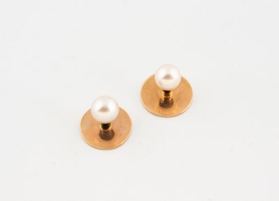 a pair of gold and pearl stud earrings on a white background