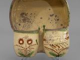 pair of ceramic owl mugs on stand on grey background