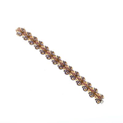 un gros plan sur un bracelet en or orné de perles violettes