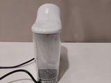 a white blender sitting on a table with a black cord