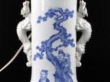 a blue and white vase with a light on it