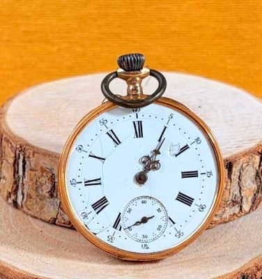 a gold pocket watch with roman numerals on it