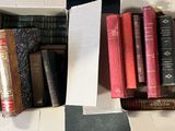 une boîte remplie de livres posée sur un sol à carreaux noirs et blancs