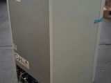 a white refrigerator sitting on the floor in a warehouse