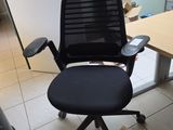 a black office chair with a black seat in a room