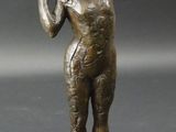 statue en bronze représentant un homme tenant une batte de baseball, posée sur un socle carré