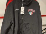 une veste noire et rouge suspendue à un portant dans un magasin