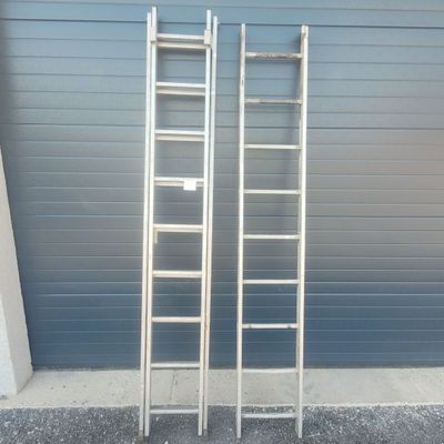 two ladders that are leaning against a garage door