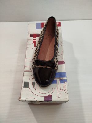 des chaussures à imprimé léopard posées sur une boîte, sur une surface blanche