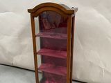 a small wooden display case with pink shelves in it