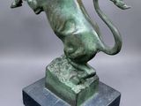 a bronze statue of a lion on a marble base