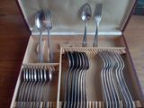 un service en argent dans un coffret en bois contenant des cuillères
