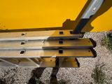 a person standing next to a ladder with a piece of metal on it