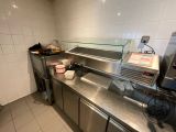 stainless steel counter top in a commercial kitchen with a glass case