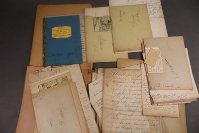 une pile de vieux papiers et de vieux livres posée sur une table