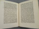 an open book with a page of text on it sitting on a table