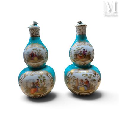 une paire de vases bleus ornés de motifs dorés sur fond blanc