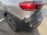 the rear end of a silver car with a red tail light on