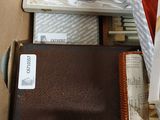 a brown suitcase sitting inside of a box with silverware in it