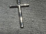 une croix posée par terre à côté d'une paire de ciseaux