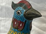 une figurine d'oiseau bleue et jaune au bec rouge
