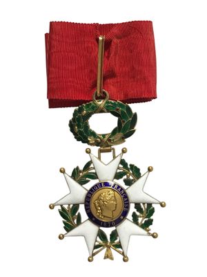 un gros plan d'une médaille accrochée à un ruban rouge sur fond blanc