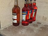 Plusieurs bouteilles d'alcool sont posées sur une étagère dans une pièce.