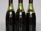 three bottles of wine are lined up on a marble surface
