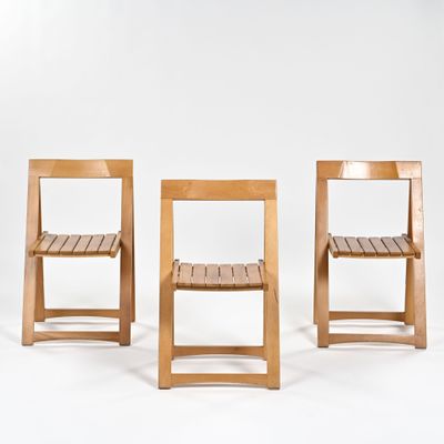 trois chaises en bois sont alignées devant un fond blanc