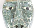 a green mask that is on display on a table