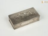 une vieille boîte en argent posée sur une table blanche
