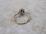 a gold ring with a flower on it sitting on a table