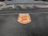 a close up of a black suitcase with a leather label