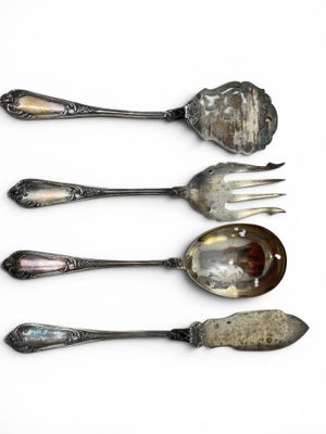 four spoons and a fork are lined up on a white surface