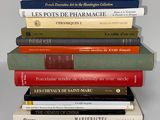 several books stacked on top of each other on a white surface