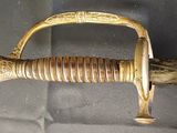 a gold colored sword with a gold handle on a gray background