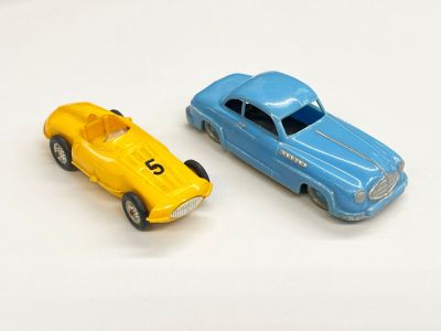 deux voitures jouets assises l'une à côté de l'autre sur une surface blanche