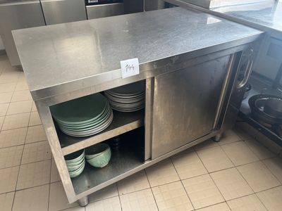 un îlot de cuisine en acier inoxydable sur lequel sont posées des assiettes et des casseroles