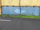 a skateboard that is sitting on the pavement in front of a wall