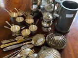 a lot of silverware on a wooden table
