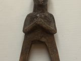 une petite sculpture en bois représentant un homme assis sur une chaise